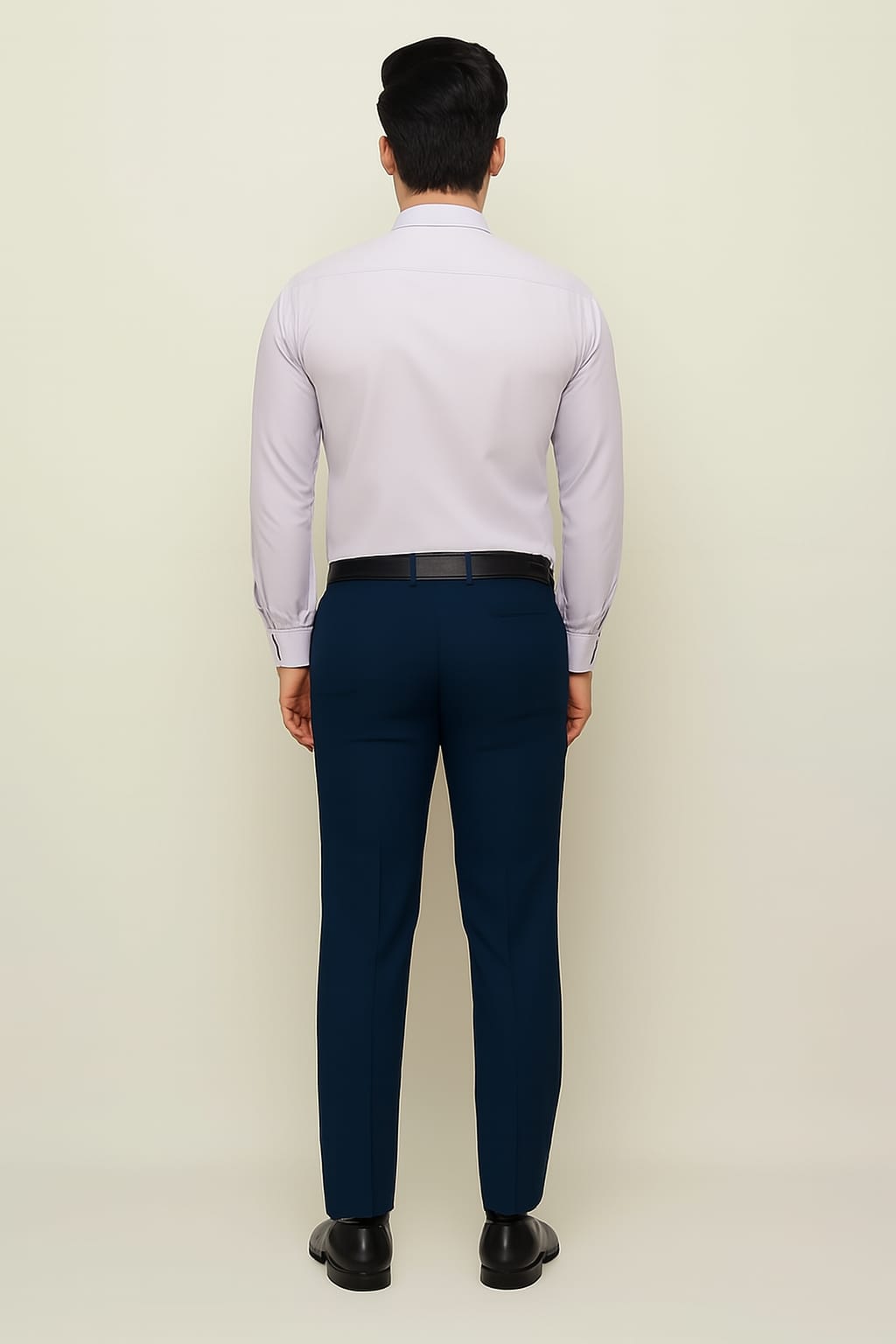 Man wearing a light purple shirt and dark blue pants on a beige background