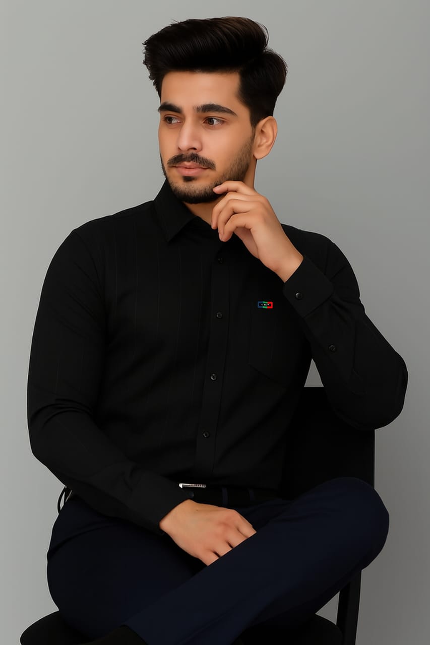 Man wearing a black shirt with a small logo on a gray background