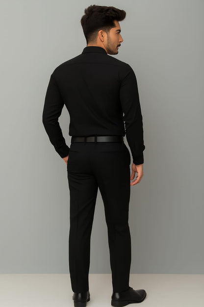 Man wearing a black outfit against a gray background