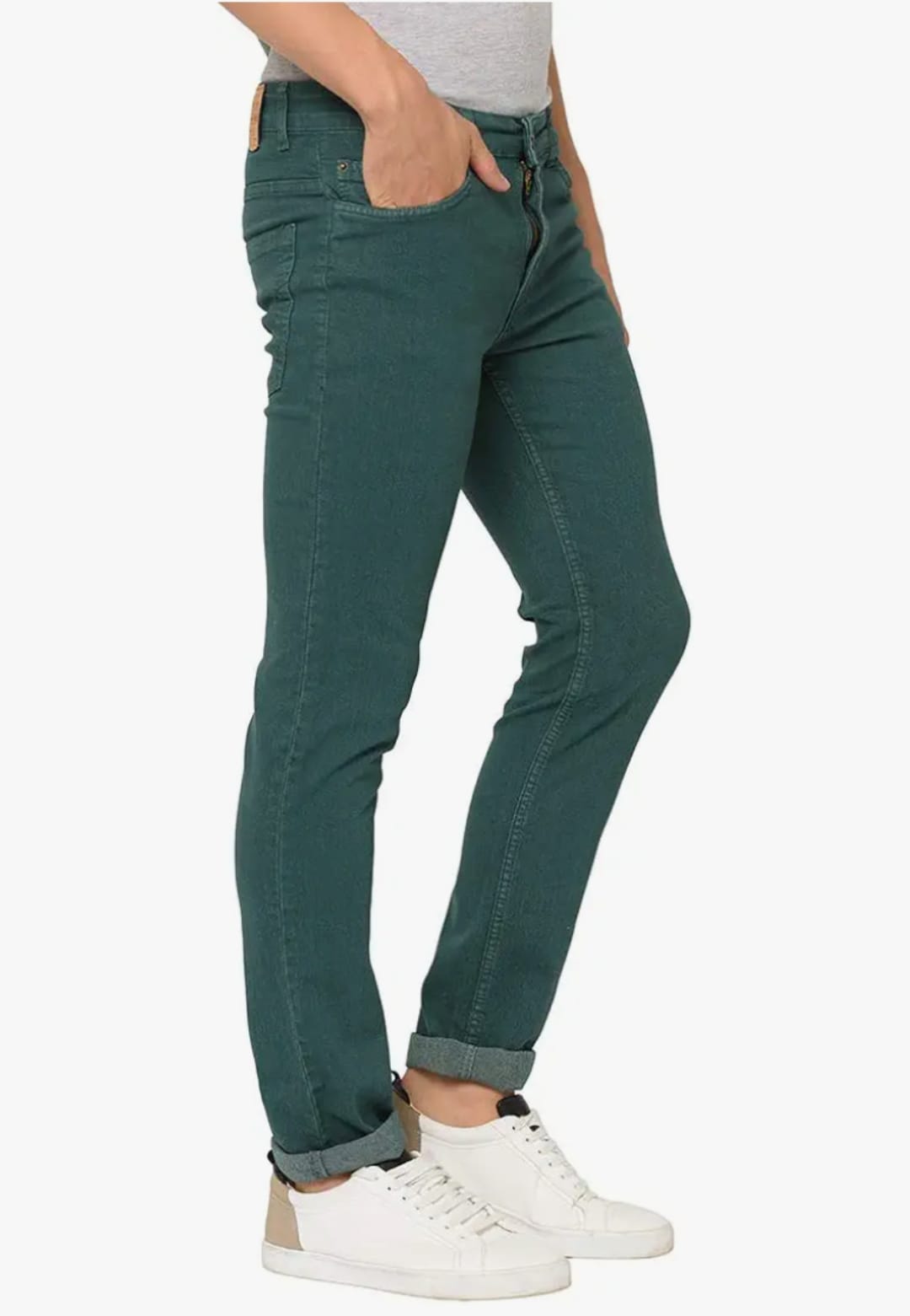 Person wearing teal jeans and white sneakers on a white background