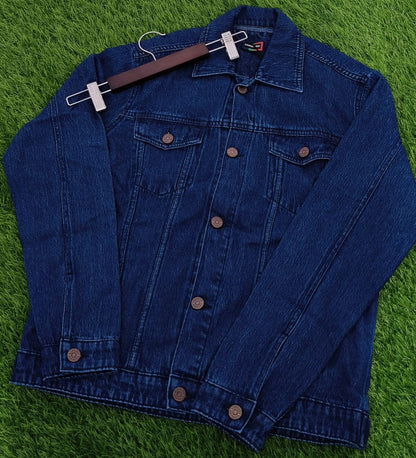 Blue denim jacket on a hanger against a green grass background