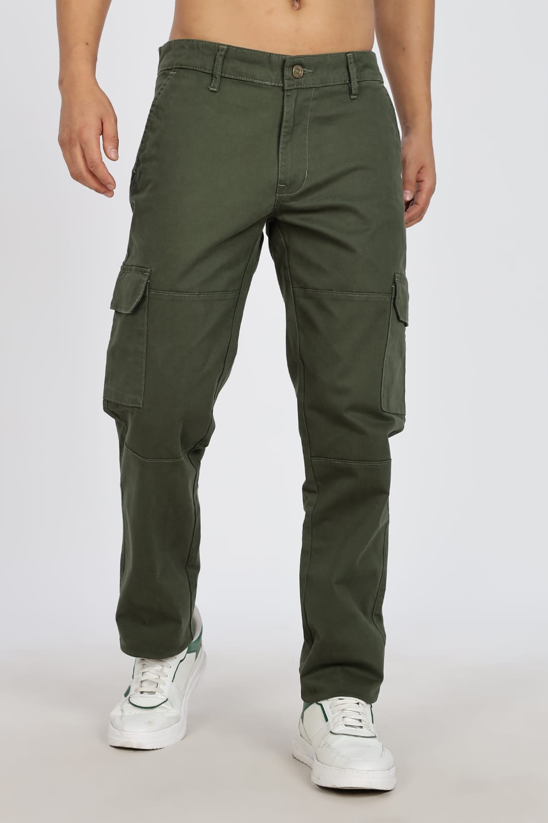 Green cargo pants worn by a person on a white background