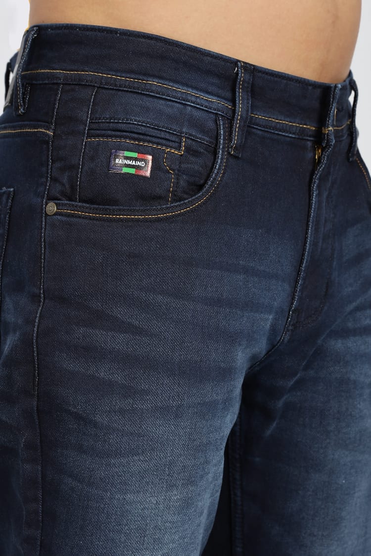 Dark blue jeans with a brand logo on the pocket against a white background