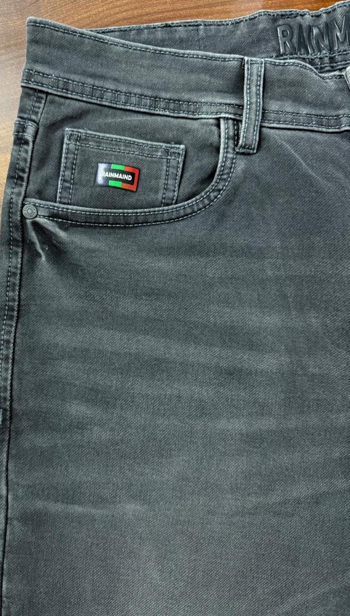 Gray pants with a brand logo on the pocket against a wooden surface