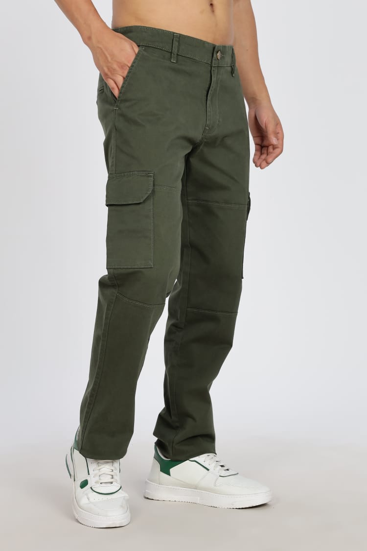 Person wearing green cargo pants on a plain background