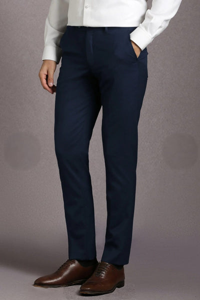 Person wearing navy pants and brown shoes on a gray background