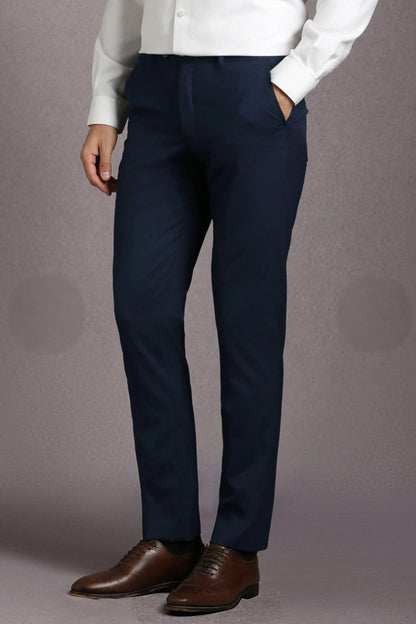 Person wearing navy pants and brown shoes on a gray background