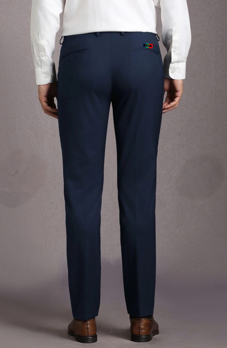 Navy pants with a brand logo on the back pocket against a gray background