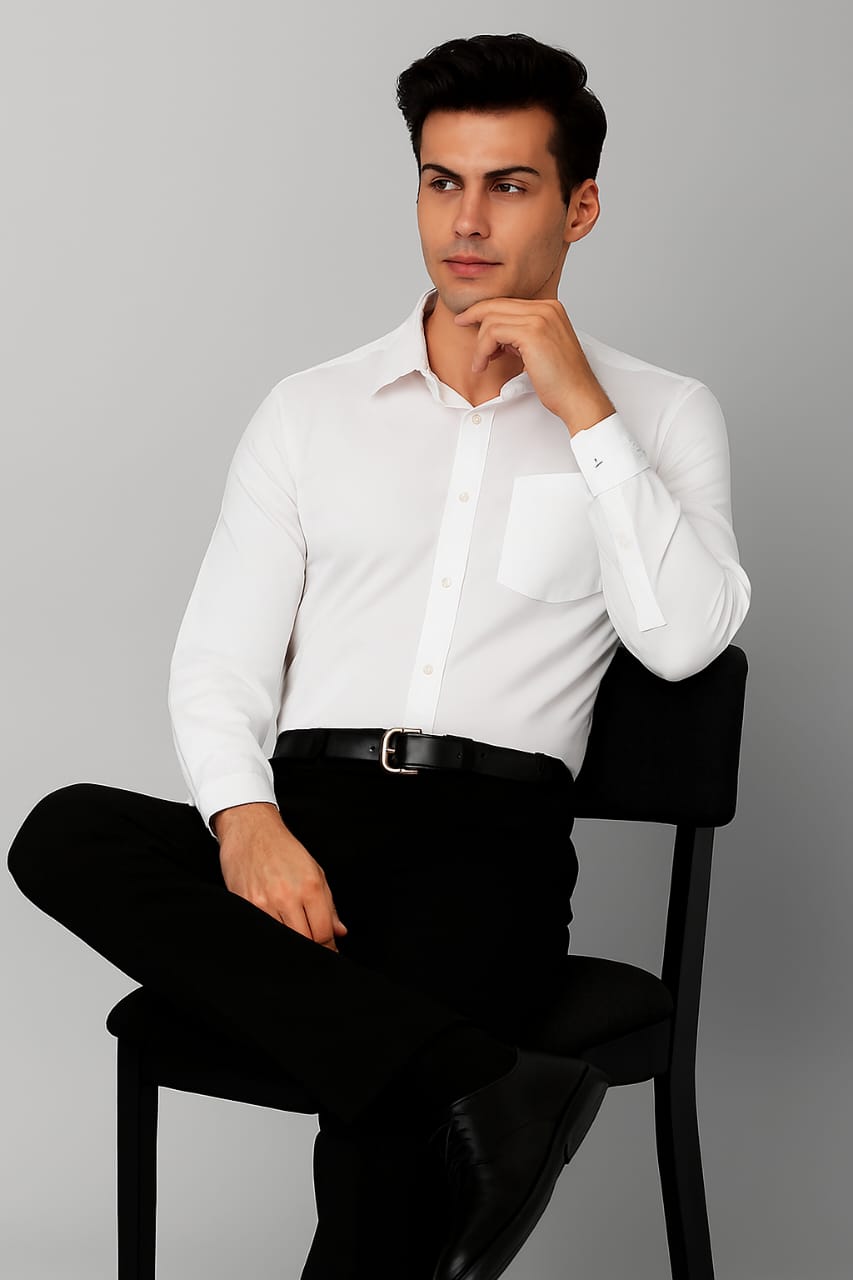 Man sitting on a chair wearing a white dress shirt and black pants against a gray background