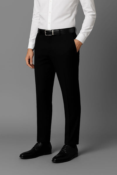 Person wearing a white dress shirt, black pants, and black shoes on a gray background
