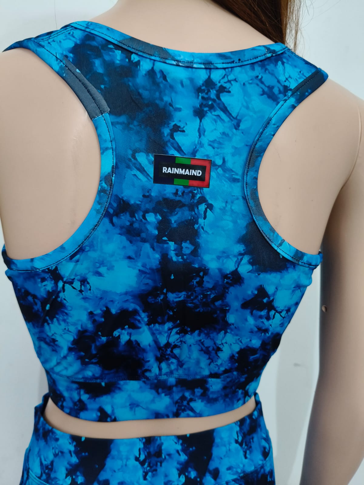 Blue tie-dye tank top with a visible brand label on a plain background