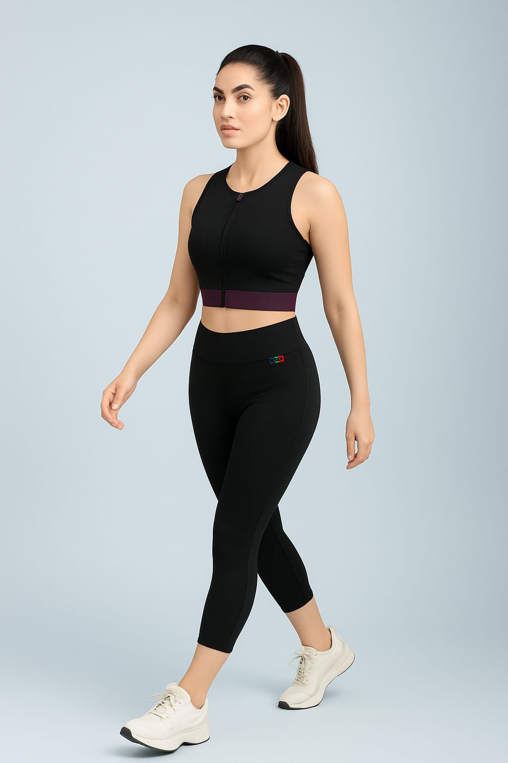 Woman wearing a black athletic outfit on a light gray background