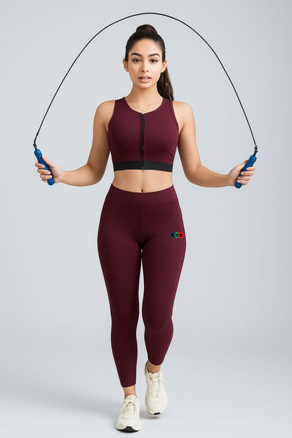 Woman in maroon athletic outfit with a jump rope on a light gray background