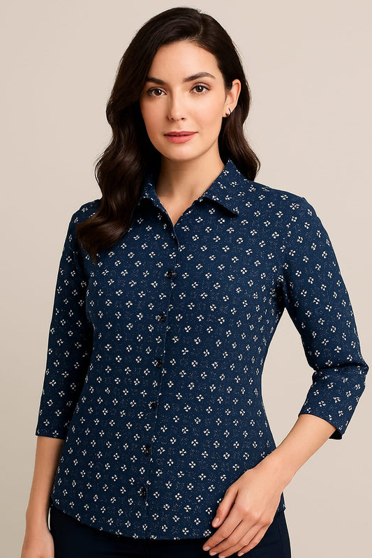 Woman wearing a navy blue patterned shirt against a beige background