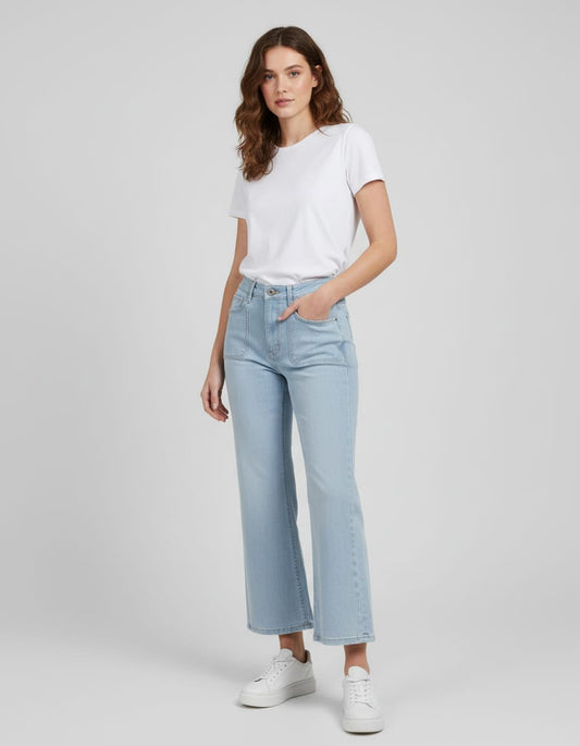 Woman wearing light blue jeans and a white t-shirt on a gray background