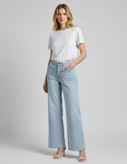 Woman wearing light blue jeans and a white t-shirt on a gray background