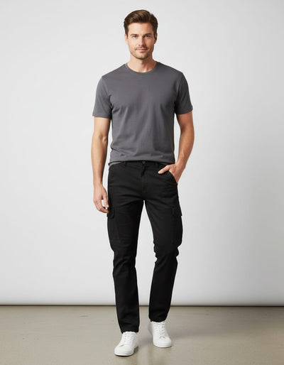 Man wearing a gray t-shirt and black pants against a white background