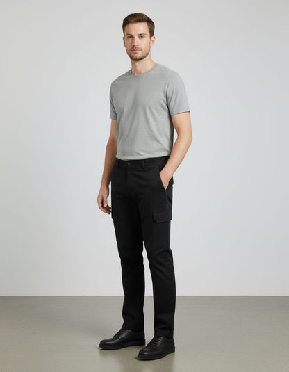 Man wearing a gray t-shirt and black pants against a plain background