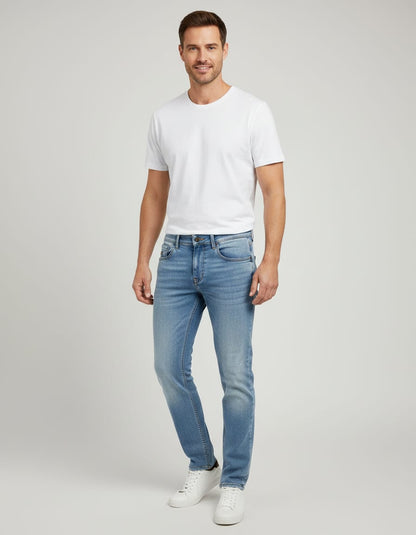 Man wearing a white t-shirt and light blue jeans on a gray background