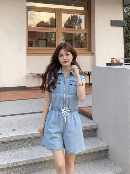 Woman in a denim outfit standing on steps outside a building.