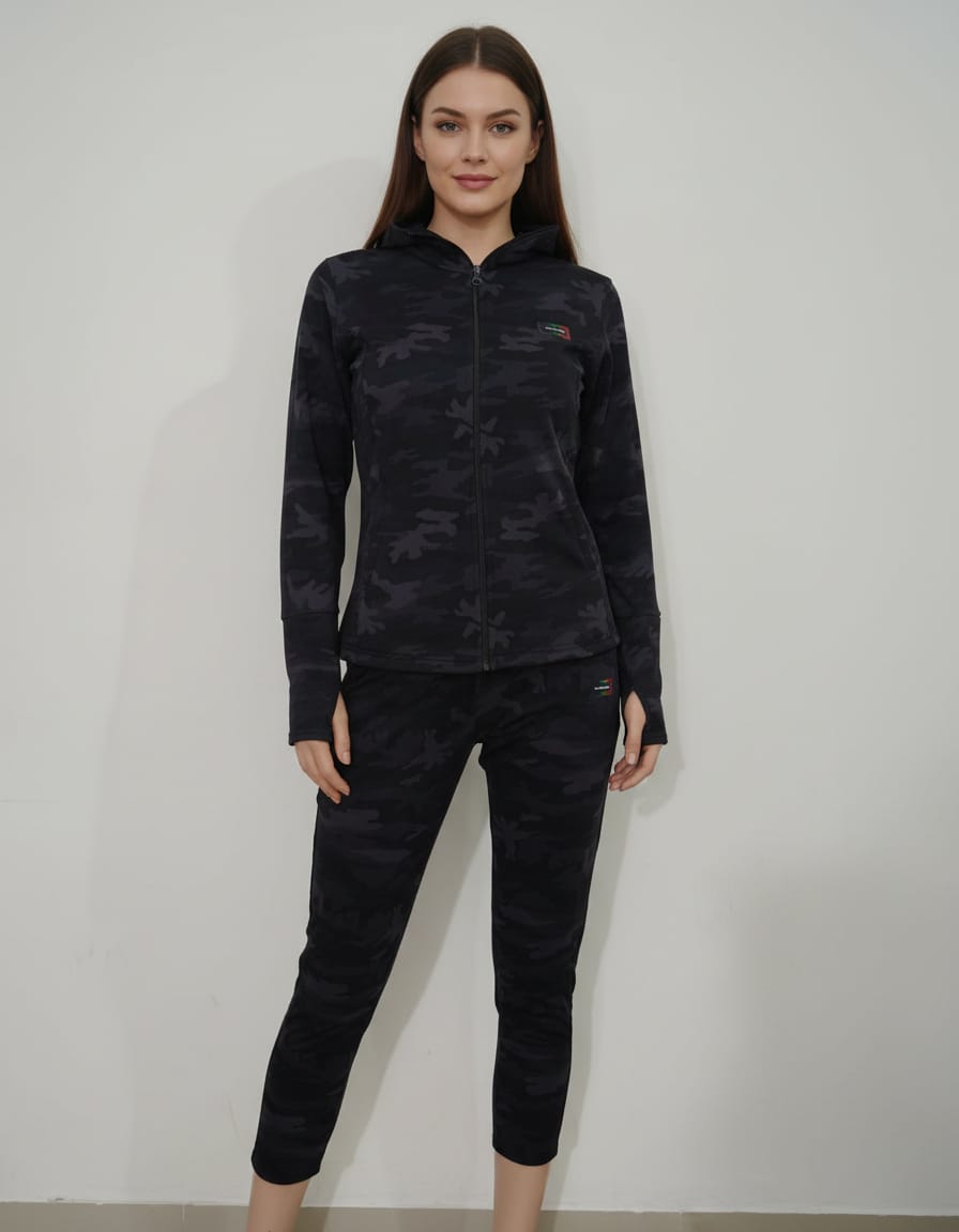 Woman wearing a black camouflage long-sleeve top and pants against a white background