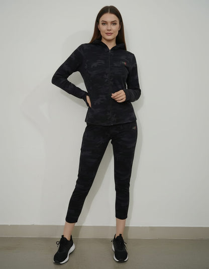 Woman wearing a black camouflage outfit against a white background