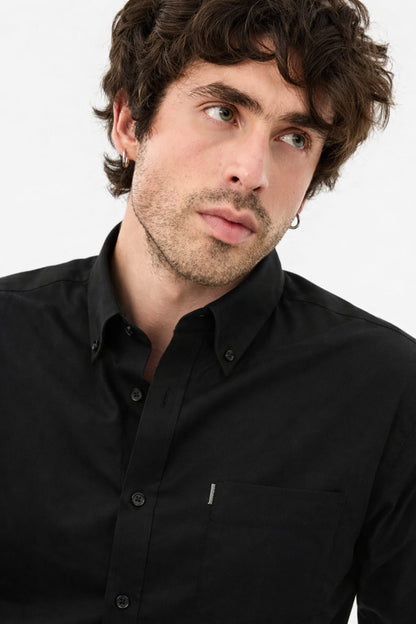 Man wearing a black shirt against a white background
