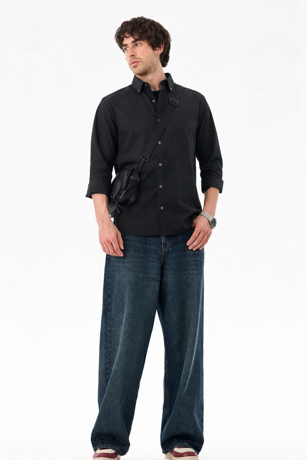 Man wearing a black shirt and blue jeans on a white background