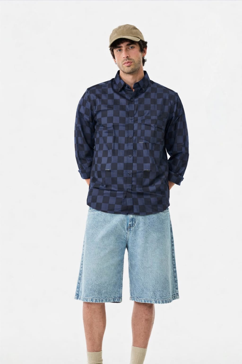 Man wearing a checkered shirt, shorts, and cap on a white background