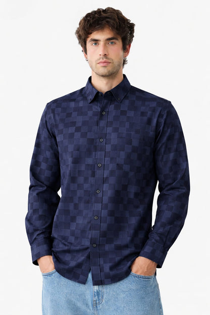 Man wearing a dark blue checkered shirt against a white background