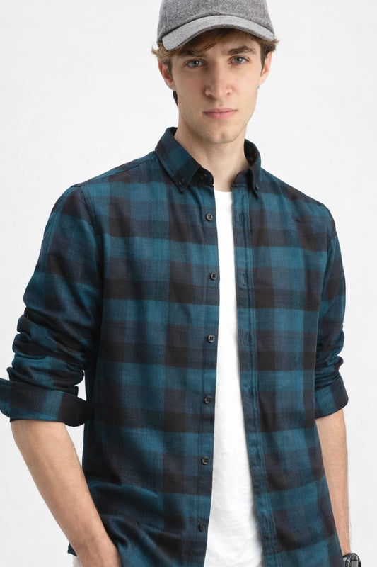 Man wearing a blue plaid shirt and gray cap on a white background