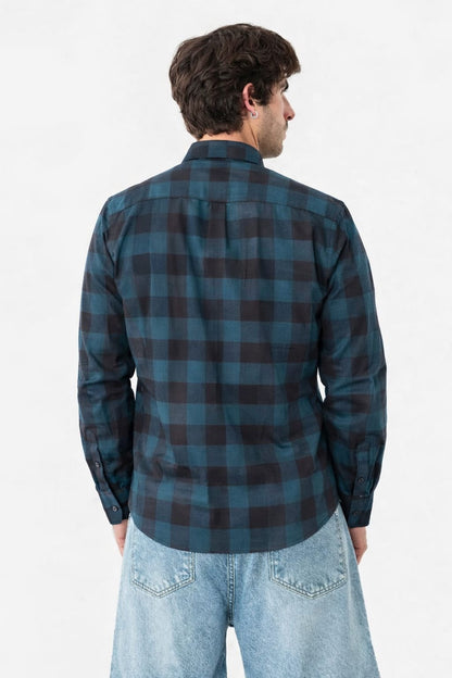 Person wearing a blue and black plaid shirt on a white background