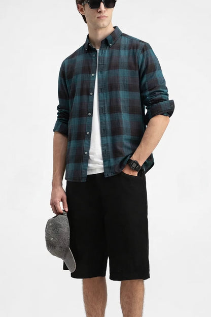 Man wearing a plaid shirt, white t-shirt, black shorts, and sunglasses on a white background