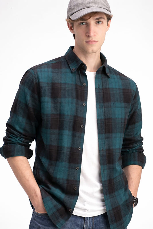 Man wearing a plaid shirt over a white t-shirt with a cap on a white background
