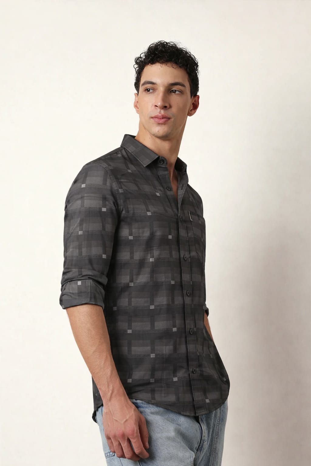 Man wearing a gray plaid shirt against a plain background