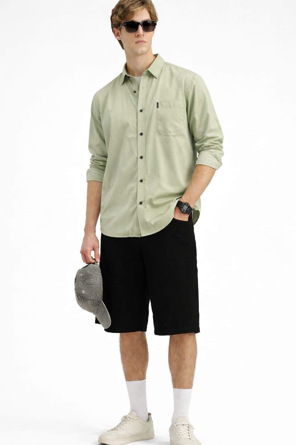 Man wearing a light green shirt, black shorts, and sunglasses on a white background
