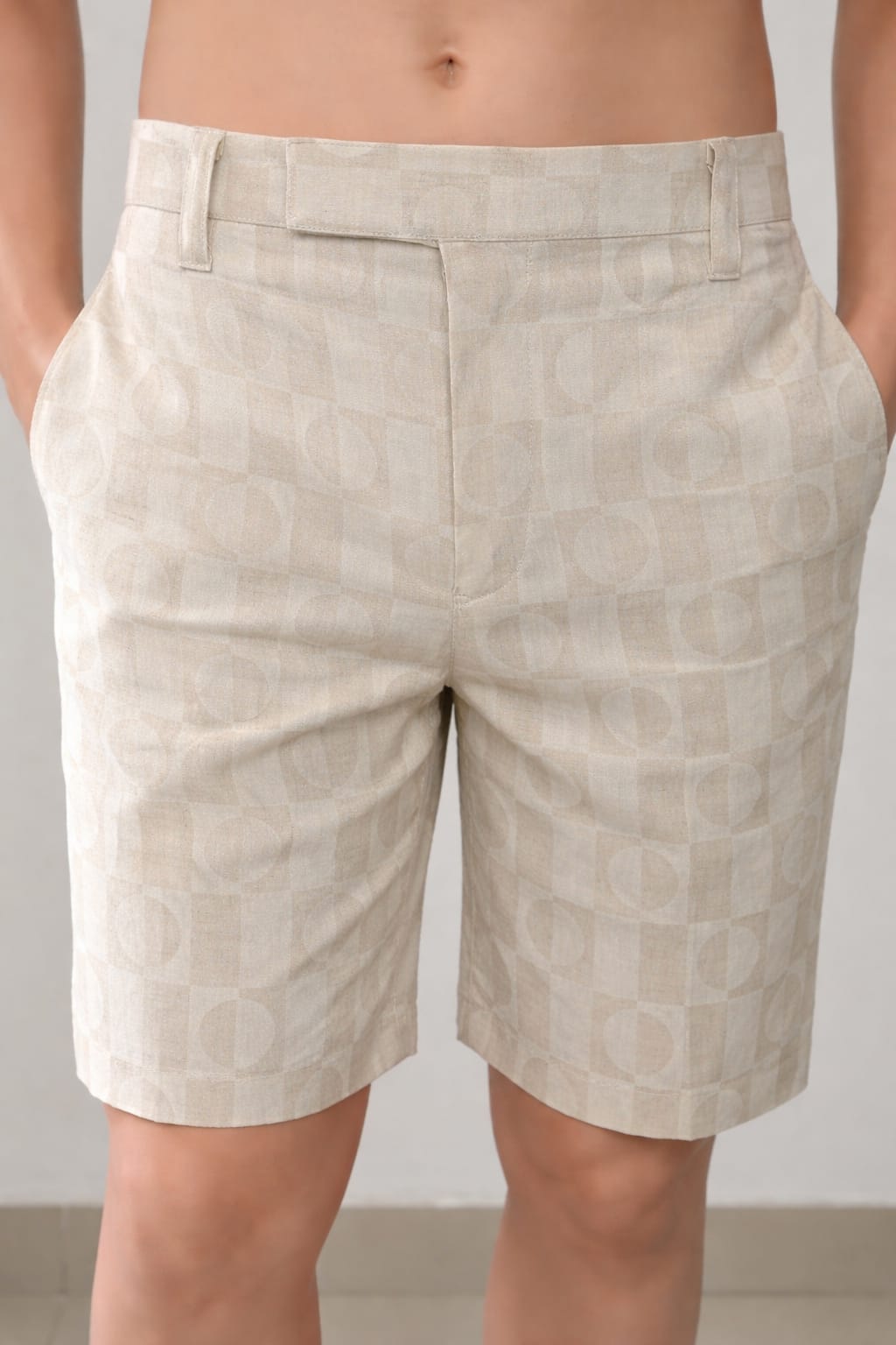 Beige shorts with a subtle pattern worn by a person against a neutral background