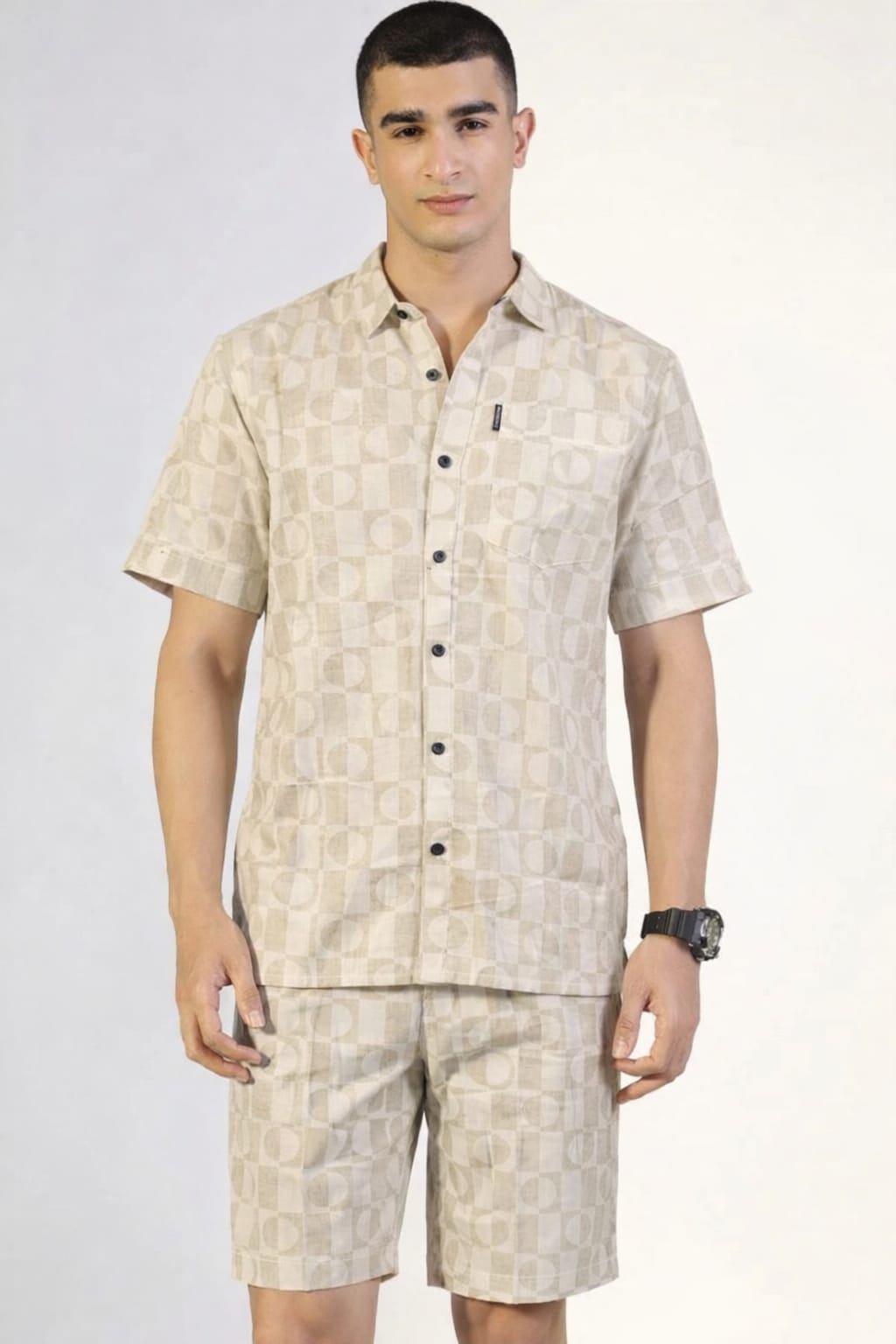 Man wearing a beige patterned shirt and shorts set on a white background