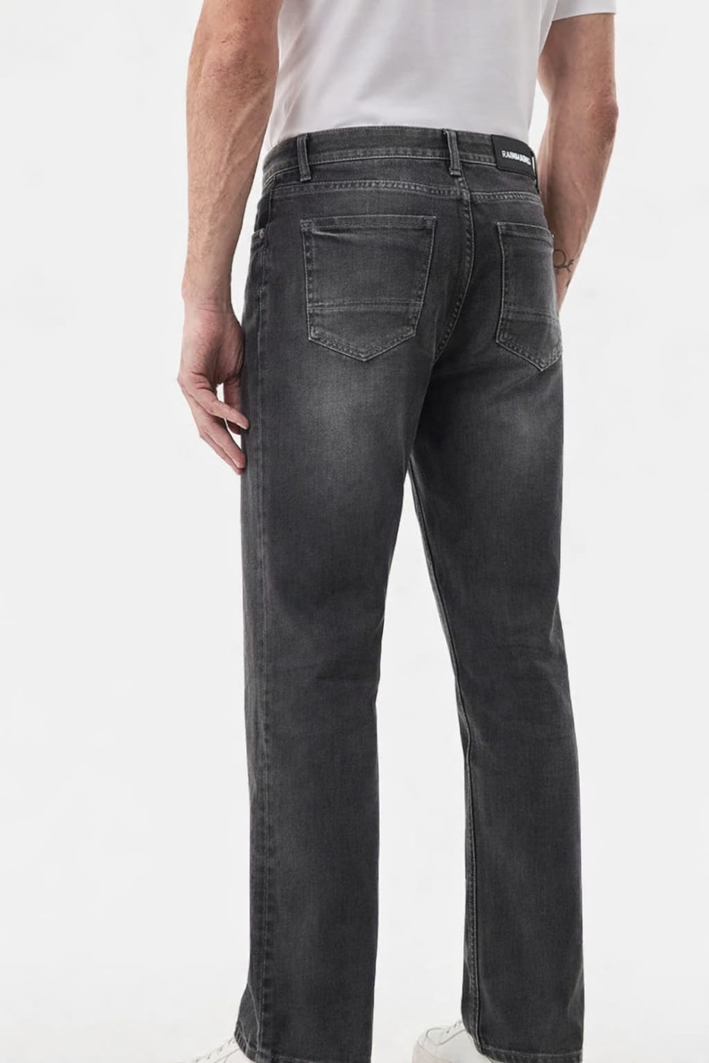 Person wearing black jeans on a white background