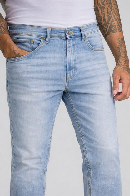 Light blue jeans worn by a person on a plain background