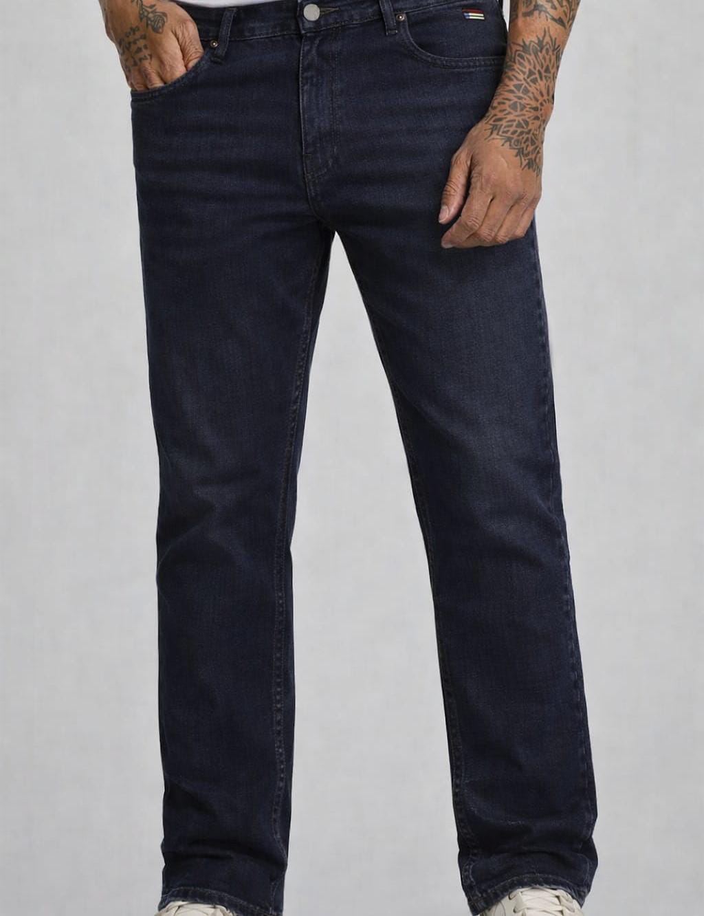 Person wearing dark blue jeans on a gray background