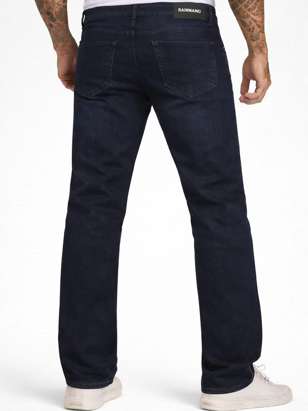 Person wearing dark blue jeans with a visible brand logo on a white background
