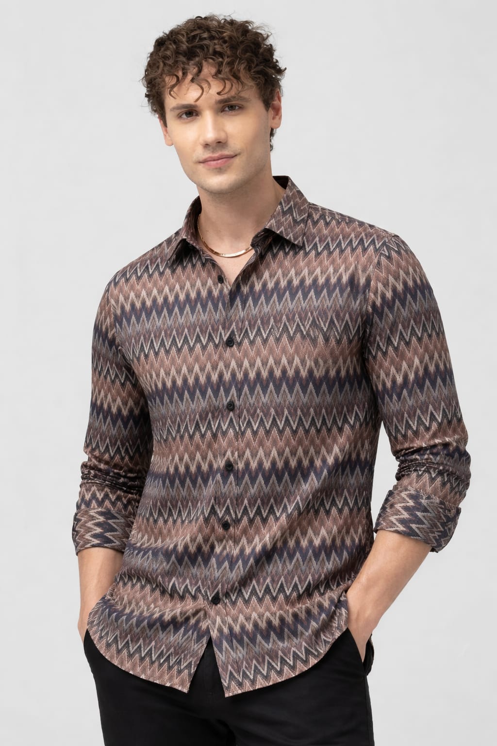 Man wearing a patterned shirt on a plain background