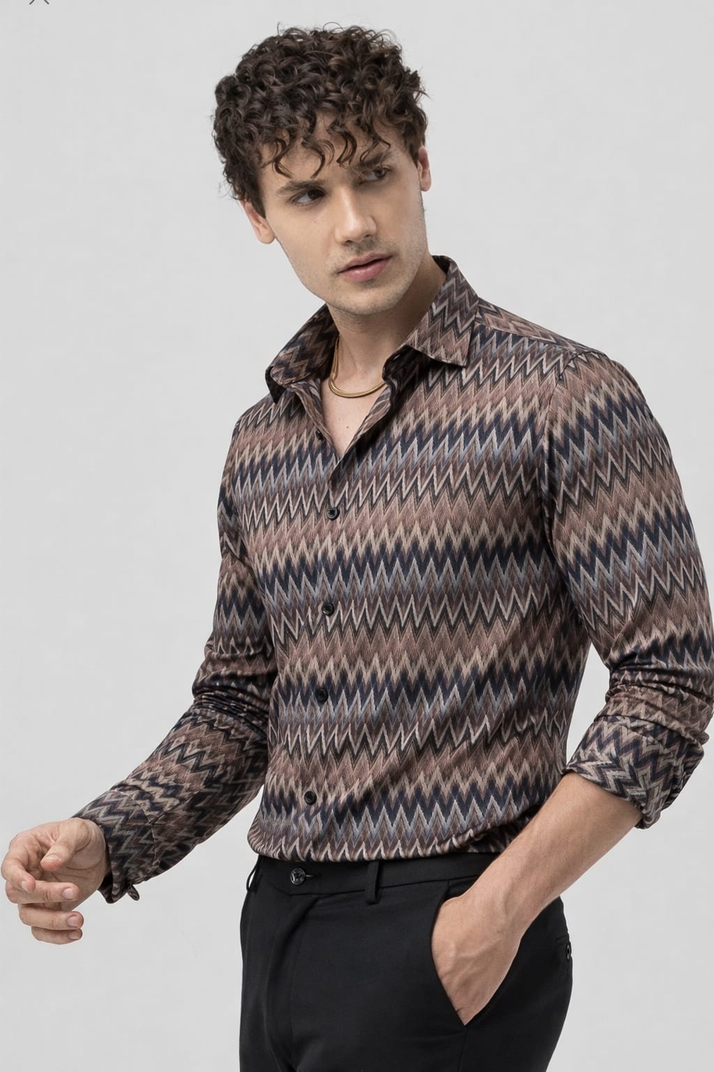 Man wearing a patterned shirt on a plain background