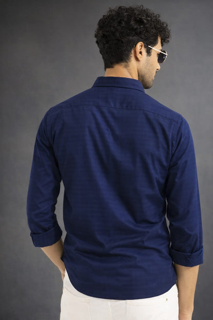 Man wearing a navy blue shirt against a gray background