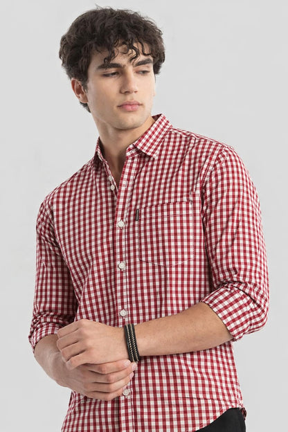 Man wearing a red and white checkered shirt against a plain background