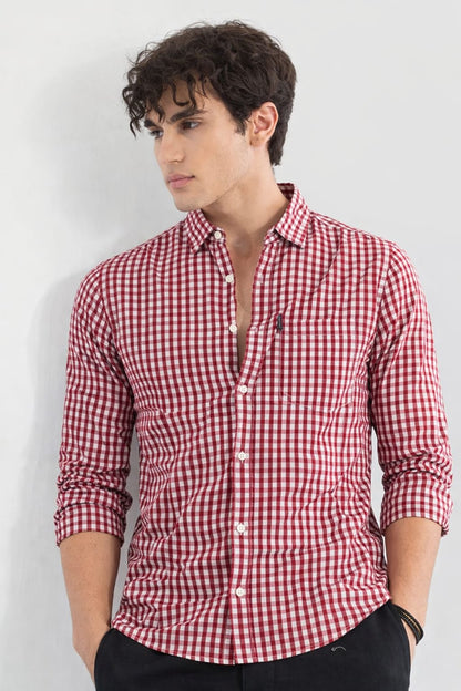Man wearing a red and white checkered shirt against a plain background