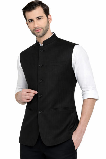 Man wearing a black vest over a white shirt on a white background