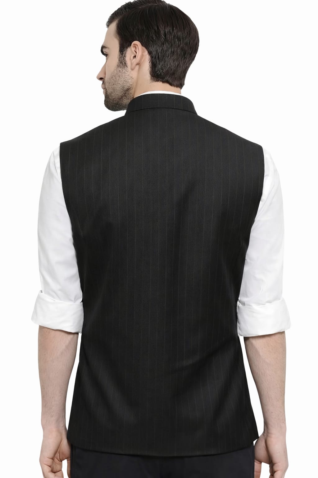 Man wearing a black vest over a white shirt on a white background