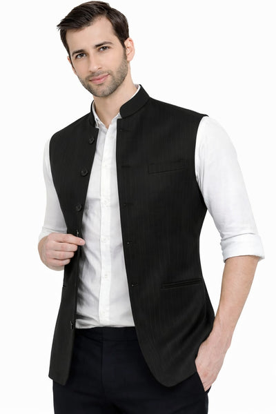 Man wearing a black vest over a white shirt on a white background
